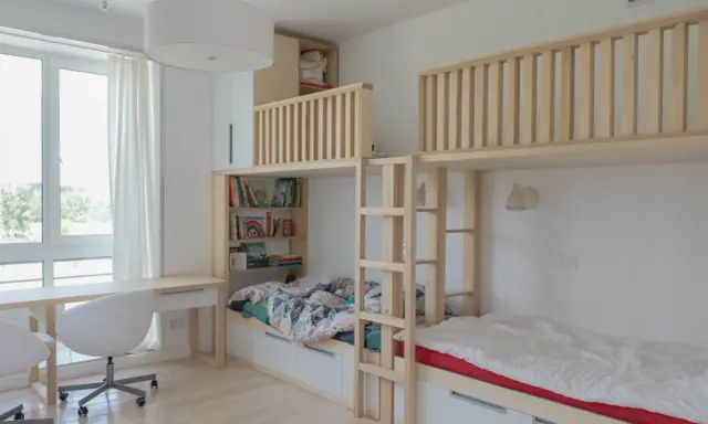 Ljust och luftigt barnrum med våningssängar i trä, bokhyllor och skrivbord. Perfekt inspiration barnrum för lek och studier.