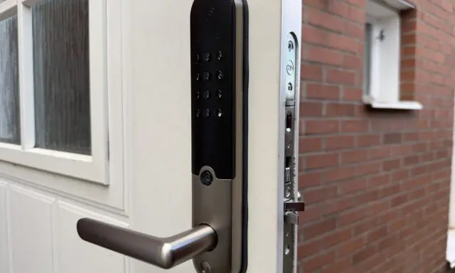 Ett modernt Yale Doorman V2N-lås på en vit dörr, redo att styras via app.