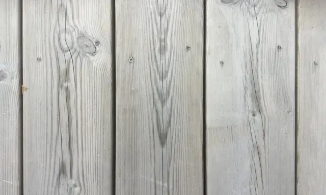 Grå träpanel med tydlig ådring, som efter kiselbehandling altan. Perfekt för en modern och hållbar uteplats.