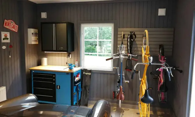 Snygga garage med cyklar upphängda, verktygsskåp och en bil. Perfekt garage inspiration för den som gillar ordning och reda.