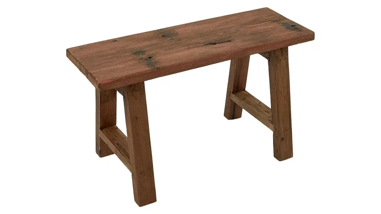 En rustik bänk i mörkt trä med synliga ådringar och en sliten yta. Perfekt för en lantlig inredning.