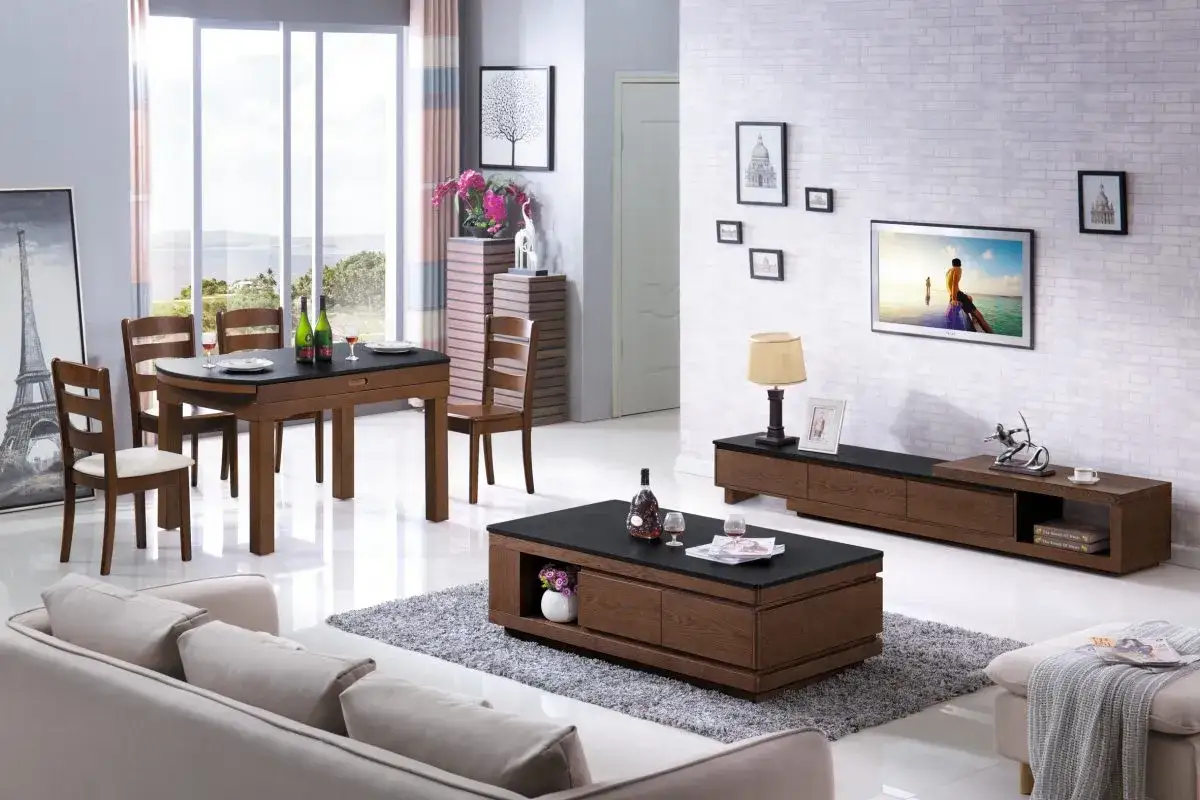 Ett modernt vardagsrum med ett elegant soffbord set i trä och svart, en soffa, TV-bänk och matgrupp.