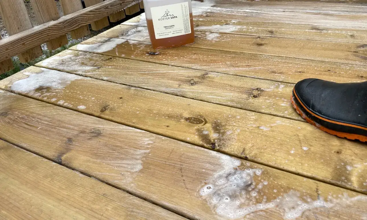 En flaska tralltv&aring;l och en st&ouml;vel redo att skura altan.