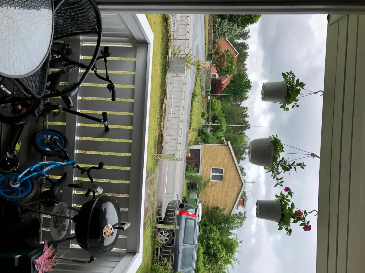 En gasolgrill under tak, redo f&ouml;r sommarens grillkv&auml;llar. Bredvid st&aring;r en bl&aring; barncykel och en svart stol.