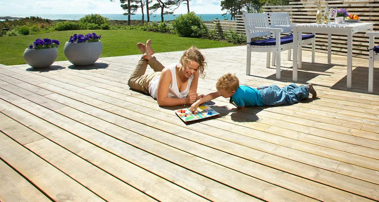 En kvinna och ett barn spelar spel på en trall altan vid havet.